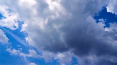 Mavi gökyüzünde hareket eden güzel beyaz bulutlar. Zaman Kucakları hareket halinde. Video ekran koruyucu için arkaplan.