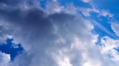 Mavi gökyüzünde hareket eden güzel beyaz bulutlar. Zaman Kucakları hareket halinde. Video ekran koruyucu için arkaplan.