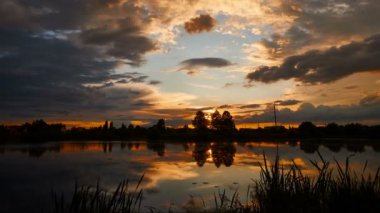 Gökyüzündeki altın bulutlu ateş gibi dramatik bir gün batımı.