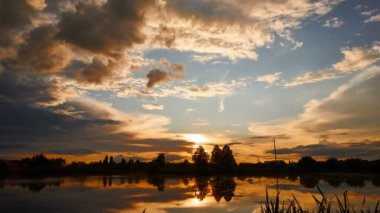 Gökyüzündeki altın bulutlu ateş gibi dramatik bir gün batımı.