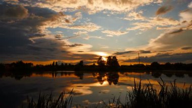 Gökyüzündeki altın bulutlu ateş gibi dramatik bir gün batımı.
