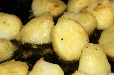 Yağlı yağda pişen leziz fırında patatesleri yakın çekim.