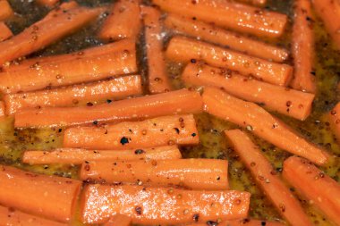 Yağda pişirilmiş ballı havuç batonlarını yakın.