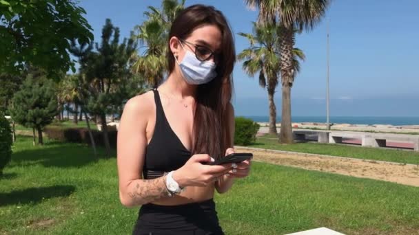 Girl Wearing Face Medical Mask Uses Smartphone Park Prevention Infection — Stock Video