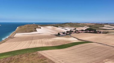 Experience the beauty of Cap Blanc Nez in France from above, revealing its dramatic cliffs and lush farmland along the coast. The serene blue waters enhance this picturesque landscape.