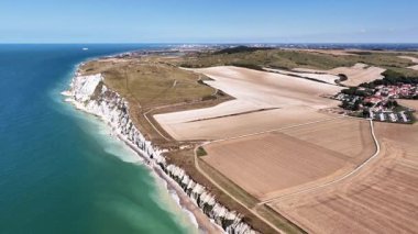 Experience the stunning aerial perspective of Cap Blanc Nez, featuring the dramatic cliffs, serene coastline, and expansive agricultural fields. A picturesque blend of nature and agriculture.