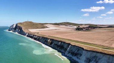 Experience the breathtaking coastal beauty of Cap Blanc Nez in France. This aerial perspective showcases the dramatic cliffs, lush fields, and serene waters under a bright blue sky.