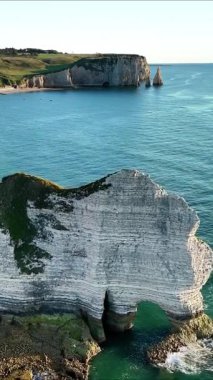 Experience breathtaking views of the cliffs of Etretat in France, showcasing their striking shapes and colors. The clear blue ocean beautifully contrasts with the rocky formations.