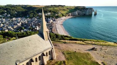 Discover breathtaking views of Etretat, France from above, showcasing its iconic cliffs, sandy beach, and the quaint village.