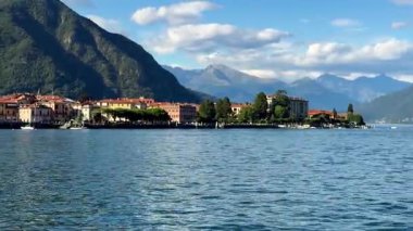 Experience the serene beauty of Lake Como, Italy, featuring picturesque lakeside buildings and majestic mountains under a clear blue sky. Enjoy the tranquil waters and scenic landscape.