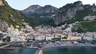 Experience the charm of Amalfi Coast, Italy from above. This breathtaking aerial view captures the vibrant buildings nestled among the cliffs and the crystal-clear sea.