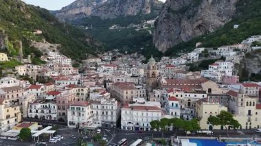 Explore the breathtaking Amalfi Coast with this aerial capture of its charming coastal town. Experience the vibrant architecture and steep cliffs in Italys stunning landscape.