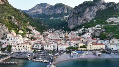 Enjoy stunning views of Amalfi Coast in Italy, featuring picturesque towns, dramatic cliffs, and clear blue waters. This aerial view captures the beauty of this famous destination.