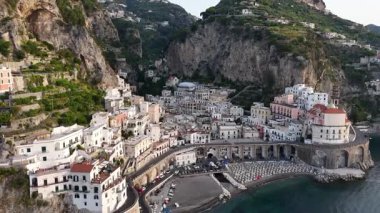 Experience breathtaking views of Amalfi Coast, where colorful cliffside towns meet the sparkling blue sea. Discover this stunning Italian treasure from above during sunset.