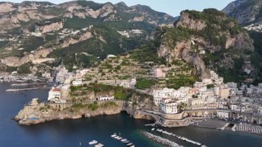 Experience the stunning beauty of Amalfi Coast in Italy from above. The aerial view highlights charming coastal villages, clear blue waters, and lush green mountains.