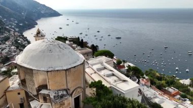 Experience breathtaking views of Positano, Italy, with its colorful buildings perched on cliffs overlooking the sparkling sea. Enjoy serenity and picturesque scenery.