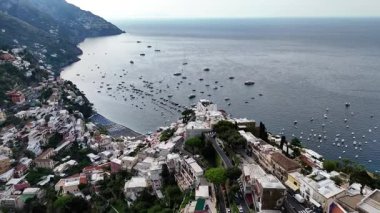 Soar above Positano, Italy and discover breathtaking views of colorful buildings cascading down the cliffs to the sparkling blue sea. Experience the towns unique charm.