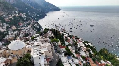 Discover the stunning aerial views of Positano, Italy. The video captures the beautiful coastline, colorful buildings, and boats dotting the azure waters. Experience the charm of this coastal gem.