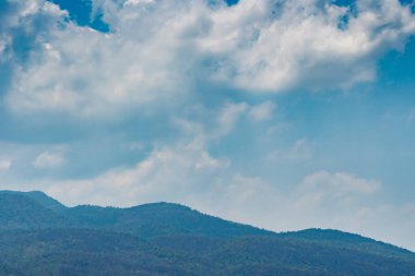 Beyaz bulut ve mavi gökyüzü ile yeşil dağ