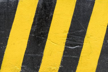 Beton duvarda siyah ve sarı trafik işareti