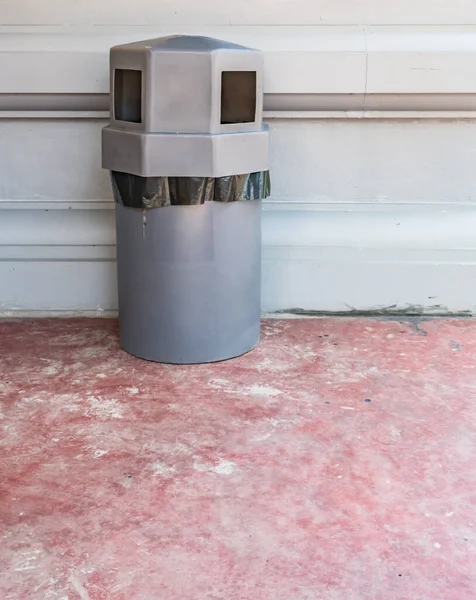 Gray trash can on concrete wall background