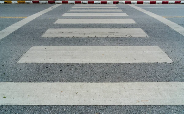 歩道の縁石に赤と白の標識とアスファルトの道路上の空の横断歩道 — ストック写真