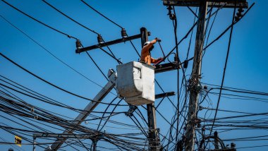 Elektrik direğiyle çalışan adam.