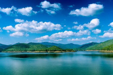 Mavi arka planda dağlı göl