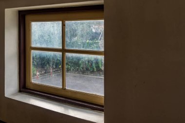 Beton duvarda ahşap çerçeveli cam pencere.