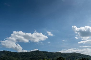 Beyaz bulut ve mavi gökyüzü ile yeşil dağ