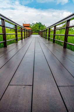 Bulutlu bir günde pirinç tarlasında tahta köprü