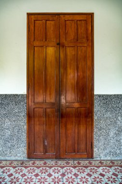 Koyu kahverengi eski tarz ahşap kapı beton duvarda