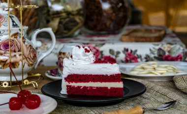 Kırmızı kadife pastayı siyah tabakta dilimle.