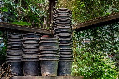 Siyah kullanılmış plastik saksılar beton zeminde