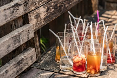 Tahta masa üzerinde saman olan boş meyve suyu bardağı seti.