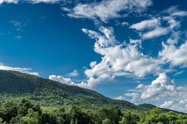 Mavi gökyüzü ve yeşil dağlı beyaz bulut