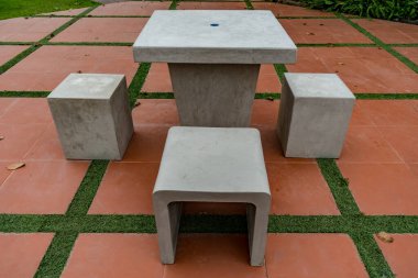 Gri beton masa ve parkın beton zemininde bank