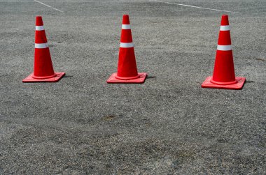 Asfalt yolda üç turuncu plastik koni