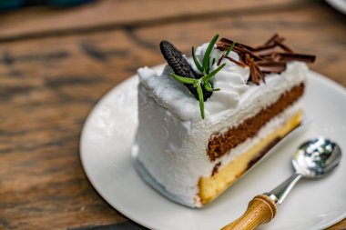 Beyaz tabakta kaşıkla dilimlenmiş kek.