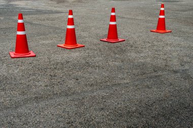 Asfalt yolda dört turuncu plastik koni