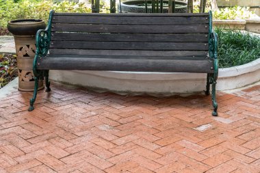 Kahverengi tuğla zeminde ahşap park bankı