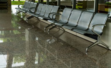 Kahverengi granit zeminde gri sıra sandalyeler