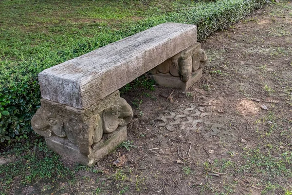 OLd wood park bench on concrete block in the park