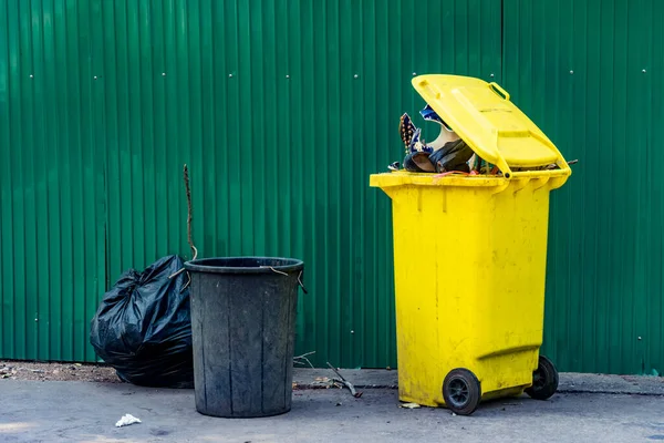 Lata Lixo Plástico Amarelo Preto Com Cerca Folha Metal Verde — Fotografia de Stock