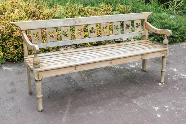 Bahçede beton zeminde ahşap park bankı