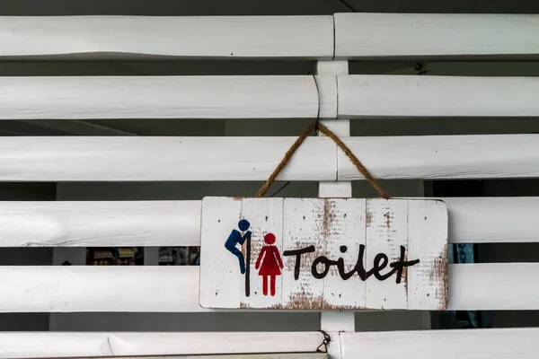 白色木制墙壁上的木制厕所标签 — 图库照片