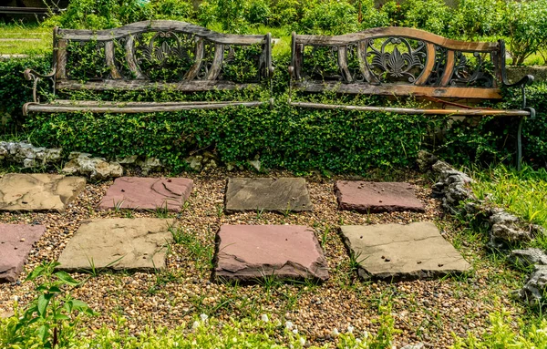公園内の緑の植物と錆びた金属公園のベンチ — ストック写真