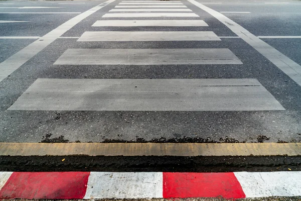 沥青路面上空旷的人行横道 人行道上有红白相间的路标 — 图库照片