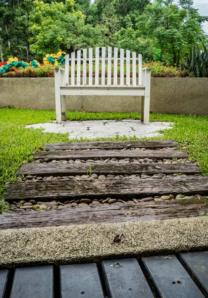 White wood park bench on concrete floor in the park