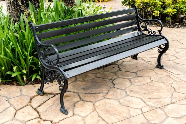 Wood park bench on concrete floor in garden